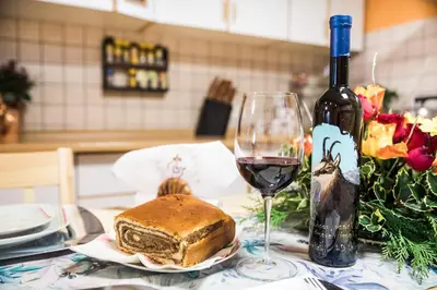 a table with a glass of wine and a loaf of bread at Počitniška hiša Pologar in Tolmin