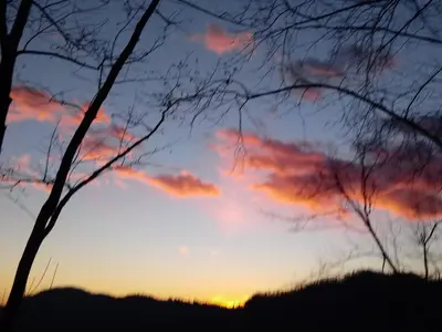 a sunset with trees in the foreground at Počitniška hiša Pologar in Tolmin