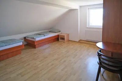 a room with two beds and a table and a window at SOSTANJ VELENJE RAVNE SOBE ROOMS Vrtacnik d o o in Šoštanj