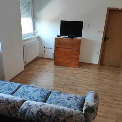 a living room with a couch and a flat screen tv at SOSTANJ VELENJE RAVNE SOBE ROOMS Vrtacnik d o o in Šoštanj