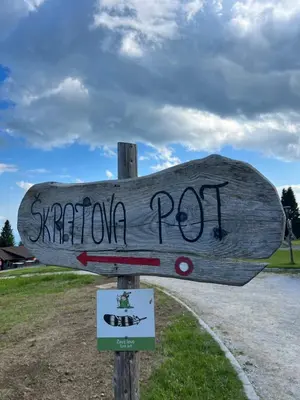 a wooden sign on a pole with graffiti on it at Chalet Klara in Resnik