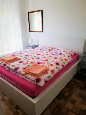 a bedroom with a bed with flowers on it at Apartma BAJČI in Ajdovščina