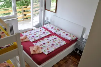 a small bedroom with a bed with a window at Apartma BAJČI in Ajdovščina
