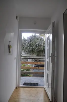 an open door to a garden with a fence at Apartma BAJČI in Ajdovščina