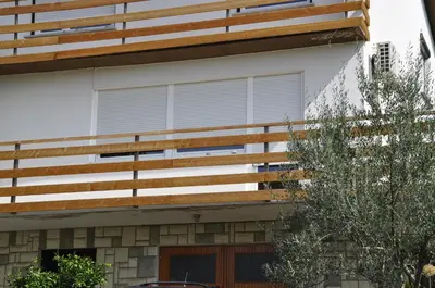 a house with a wooden deck on the side of it at Apartma BAJČI in Ajdovščina
