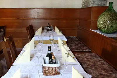 a long table with wine glasses and a vase at Guesthouse Risnik in Divača