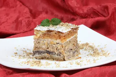 a piece of cake on a plate on a red blanket at Guesthouse Risnik in Divača