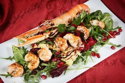 a plate of food with shrimp and a salad at Guesthouse Risnik in Divača