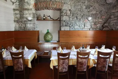 a dining room with tables and chairs and a vase at Guesthouse Risnik in Divača