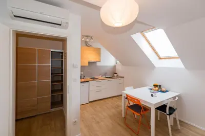 a kitchen with a white table and a skylight at Central Apartments with Parking in Ljubljana