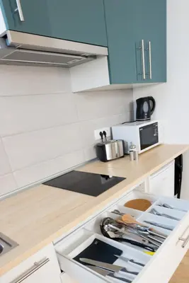 a kitchen with blue cabinets and a counter top at Central Apartments with Parking in Ljubljana