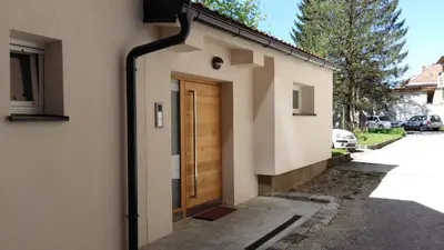 a house with a wooden door on the side of it at Central Apartments with Parking in Ljubljana