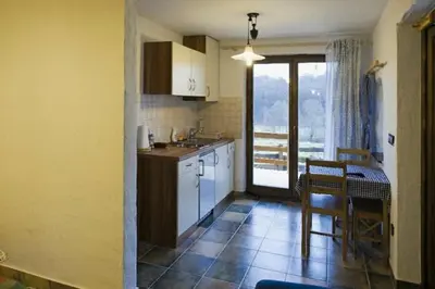 a kitchen with a table and a dining room at Apartments Mali Raj in Dolenci