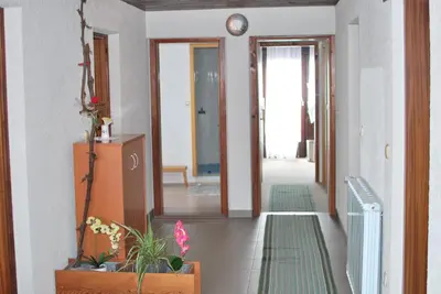 a hallway with doors and plants on the floor at Farm Stay Bogša in Ormoz