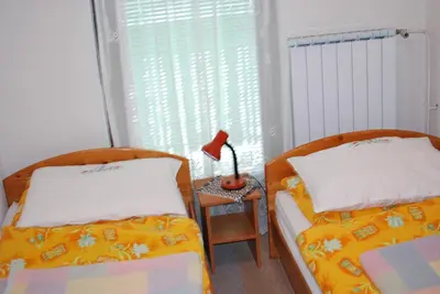a bedroom with two beds and a lamp on a table at Farm Stay Bogša in Ormoz