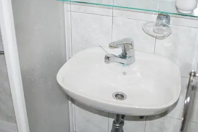 a white sink in a bathroom with a glass at Farm Stay Bogša in Ormoz
