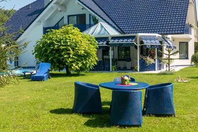 a blue table in the yard of a house at Modrin Apartments in Kamnik