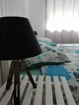 a lamp sitting on a table next to a bed at Naturalina in Tolmin