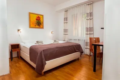 a bedroom with a bed and a table and a window at Penzion Pod Lipo in Ljubljana