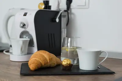 a table with a coffee maker and a loaf of bread at Boomerang Apartment Bled in Bled
