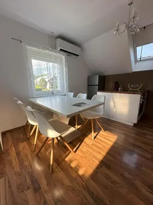 a dining room with a table and white chairs at Boomerang Apartment Bled in Bled