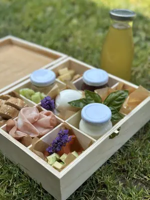 a wooden box filled with food and a bottle of juice at Boomerang Apartment Bled in Bled