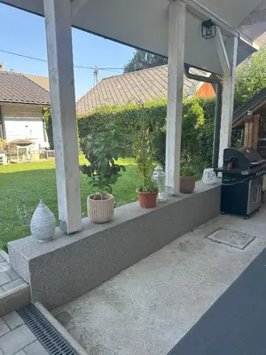 a porch with potted plants and a grill at Boomerang Apartment Bled in Bled