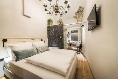 a bedroom with a large bed and a chandelier at Hotel Pok Garni in Brezovica