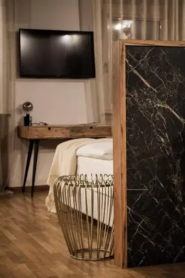 a room with a table with a tv and a radiator at Hotel Pok Garni in Brezovica