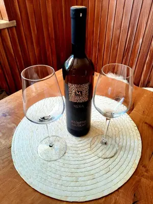 a bottle of wine and two wine glasses on a table at Apartments Vidic in Bled