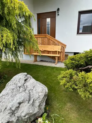 a wooden bench in a yard with a rock at Apartments Vidic in Bled