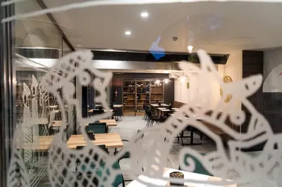 a glass window of a restaurant with tables and chairs at Hostel Situla in Novo Mesto