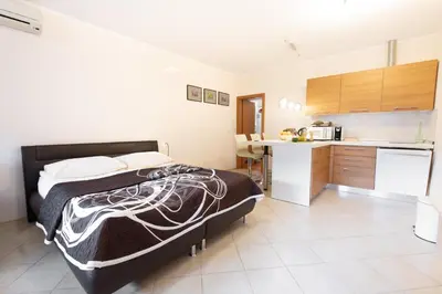 a bedroom with a bed and a small kitchen at Apartments Pri nas in Kobarid