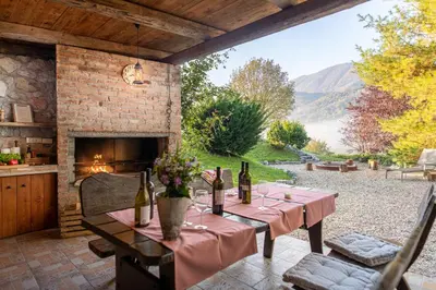 a table with wine bottles and flowers on a patio at Apartments Pri nas in Kobarid