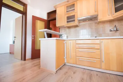 a kitchen with wooden cabinets and wooden floors at Apartment Tiara 2 in Rodine