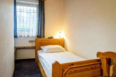 a small bedroom with a bed and a window at Garni Hotel Berc in Bled