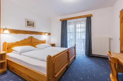 a bedroom with a wooden bed and a window at Garni Hotel Berc in Bled