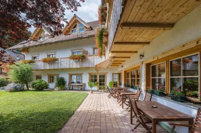 an outdoor patio with wooden tables and chairs at Garni Hotel Berc in Bled
