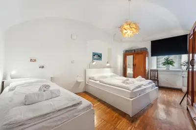a bedroom with two beds and a chandelier at ROG Apartment with Furnished Courtyard in Ljubljana
