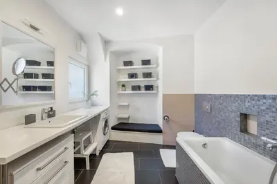a white bathroom with a tub and a sink and a bath tub at ROG Apartment with Furnished Courtyard in Ljubljana