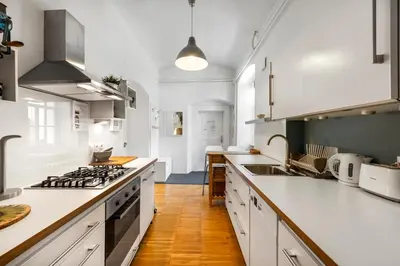 a kitchen with white cabinets and a stove top oven at ROG Apartment with Furnished Courtyard in Ljubljana