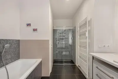 a white bathroom with a tub and a shower at ROG Apartment with Furnished Courtyard in Ljubljana
