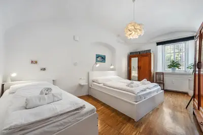 a bedroom with two beds and a chandelier at ROG Apartment with Furnished Courtyard in Ljubljana