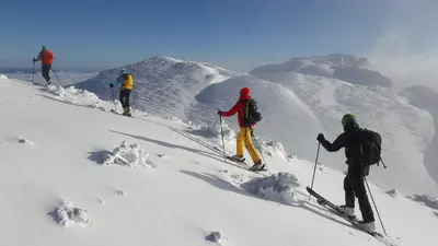 a group of three people on a snow covered mountain at BikeSki family hotel, b&b, apartaments, rooms in Mežica