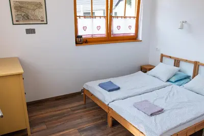 a bedroom with two beds and a window at BikeSki family hotel, b&b, apartaments, rooms in Mežica