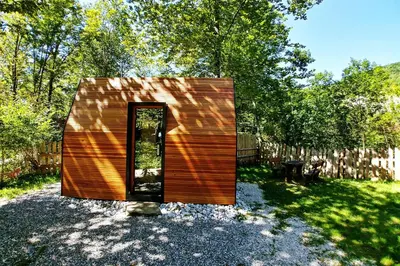 a small wooden house with a door in a yard at Kamp Koren Kobarid in Kobarid