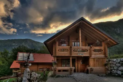 a log cabin in the mountains under a cloudy sky at Kamp Koren Kobarid in Kobarid