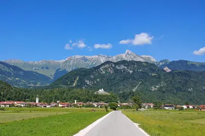 a road leading through a field with mountains in the background at Kamp Koren Kobarid in Kobarid