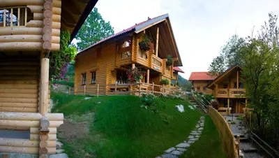 a log cabin with a porch and a pathway leading to it at Kamp Koren Kobarid in Kobarid