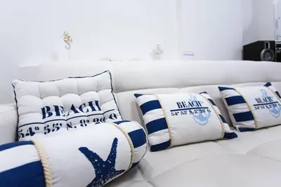 a white couch with blue and white pillows on it at Blue Point Apartment Ljubljana in Ljubljana